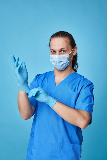 Jeune homme médecin en uniforme portant des gants