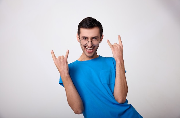 Un jeune homme mignon dans un T-shirt bleu s'amuse sur un blanc.