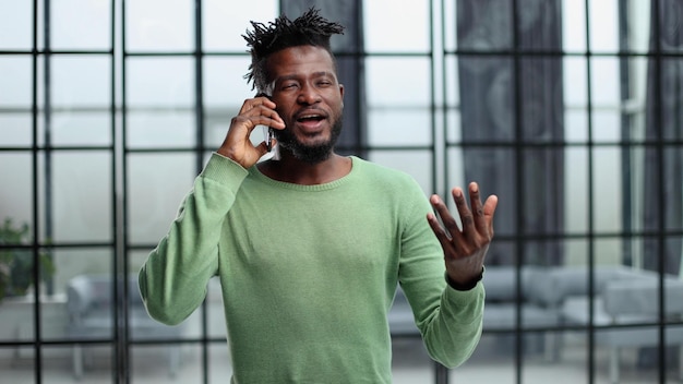 Jeune homme moderne avec téléphone portable au bureau