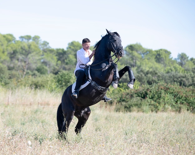 Jeune homme monté sur un cheval dans la nature