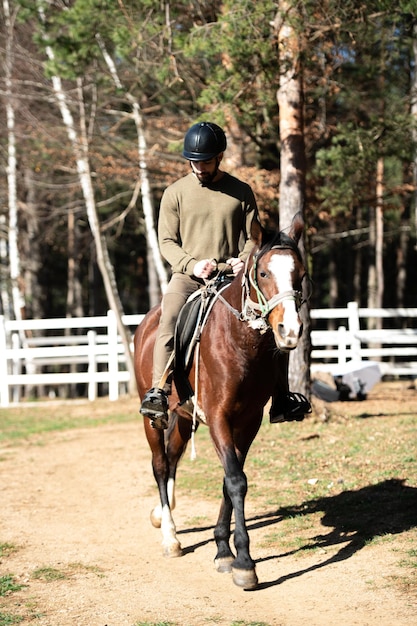 Jeune homme monte un cheval portant un casque