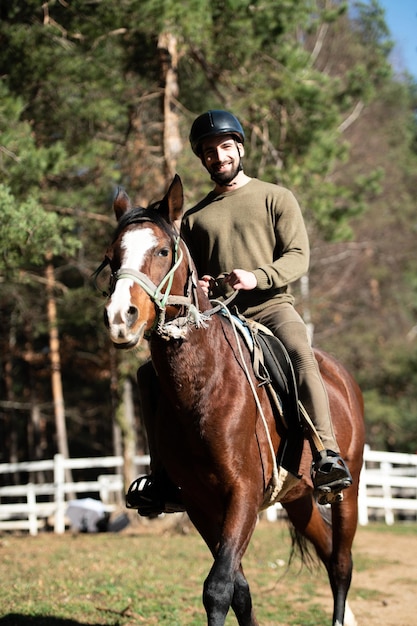 Jeune homme monte un cheval portant un casque