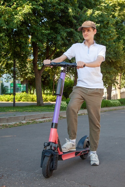 Un jeune homme monte un scooter électrique loué dans le parc