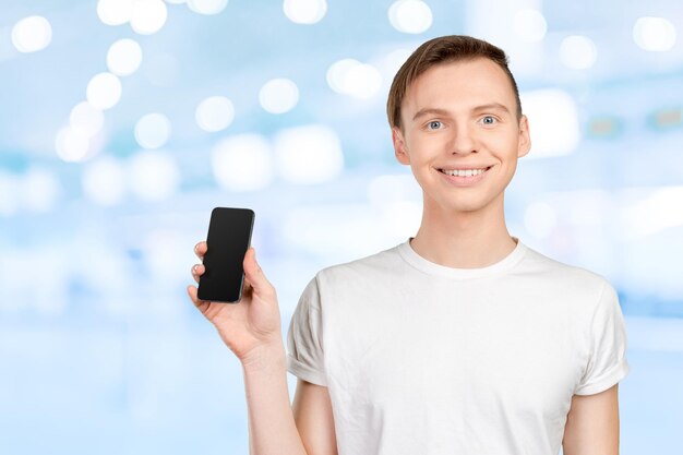 Jeune homme montrant un écran vide de téléphone intelligent