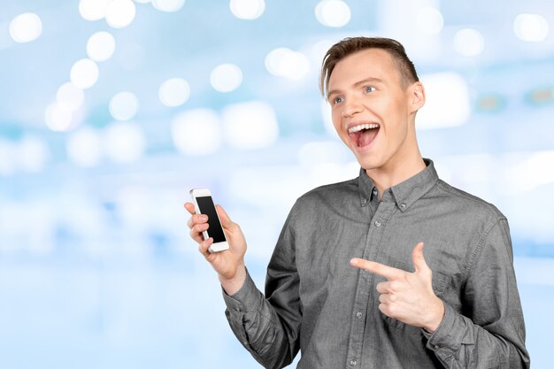 Jeune homme montrant un écran vide de téléphone intelligent