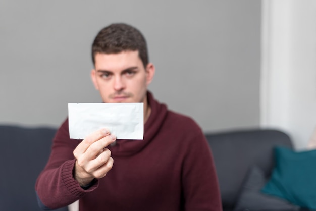 Jeune homme montrant un paquet vide à la maison Concept de produit avec espace de copie au texte