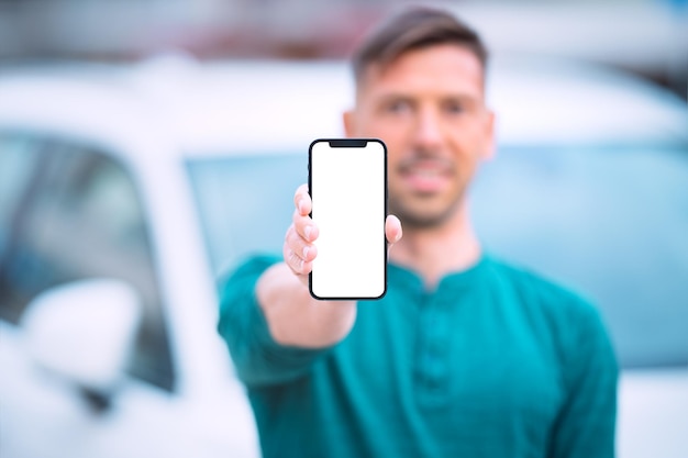 Jeune homme montrant son téléphone avec un écran vierge ou une maquette d'espace vide