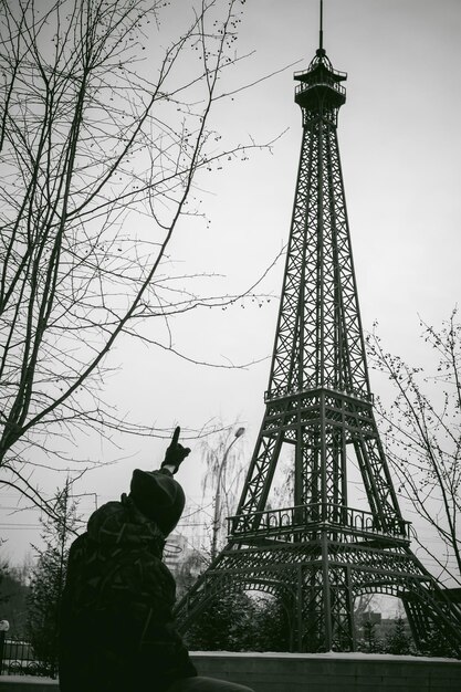 Photo un jeune homme montrant la tour pendant l'hiver