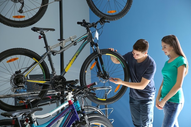 Jeune homme montrant un vélo à une fille dans un magasin