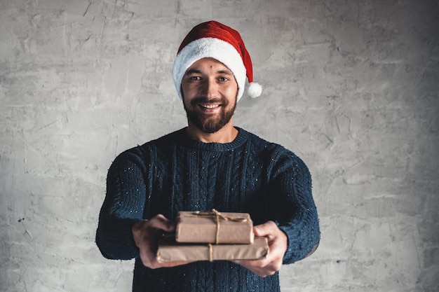 Le jeune homme montre la boîte-cadeau de papier d'artisanat brun