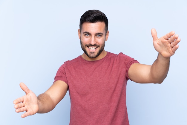 Jeune homme sur mur bleu isolé