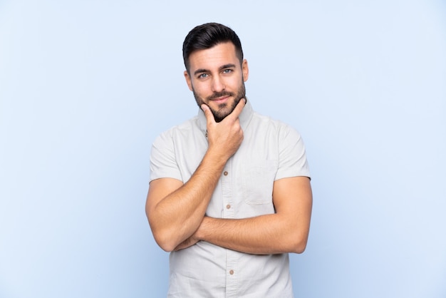 Jeune homme sur mur bleu isolé