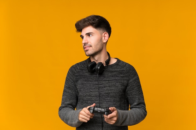 Photo jeune homme sur un mur isolé jouant à des jeux vidéo