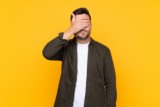 Jeune homme sur mur jaune isolé