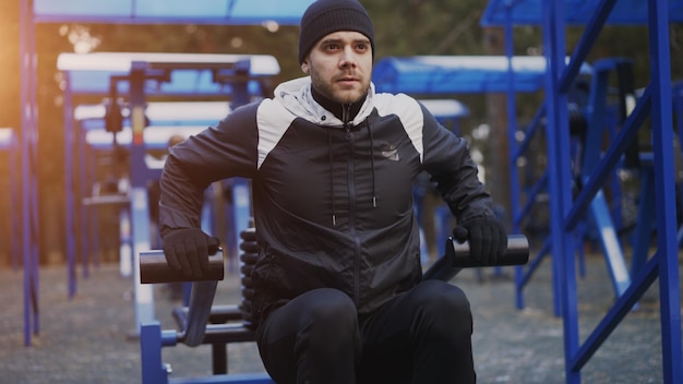 Jeune homme musclé faisant de l'exercice dans une salle de sport en plein air à winter park