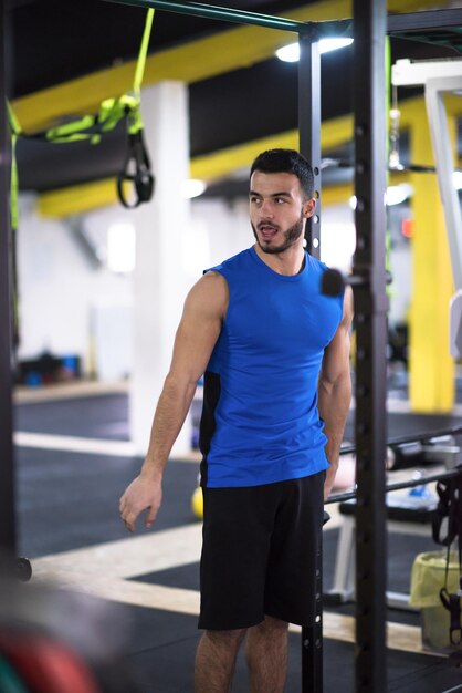 Photo jeune homme musclé fait des tractions sur le bar verticall dans le cadre de l'entraînement de fitness cross