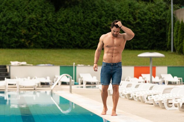 Jeune homme musclé à la piscine extérieure