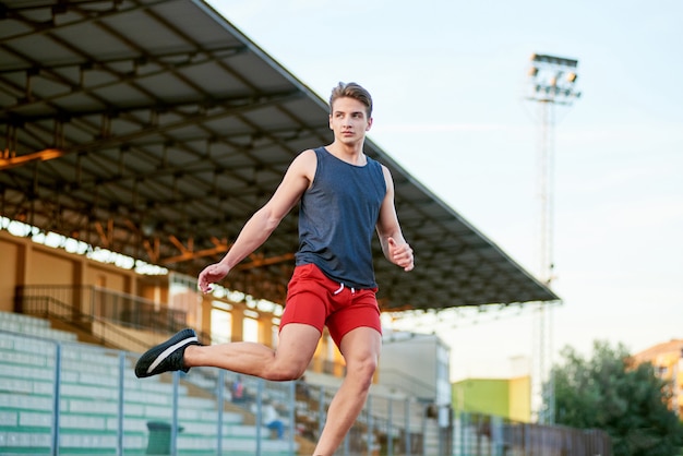 Jeune Homme Musclé Qui Court Sur La Piste