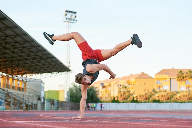 Jeune homme musclé, rester tête baissée d'une part sur le stade