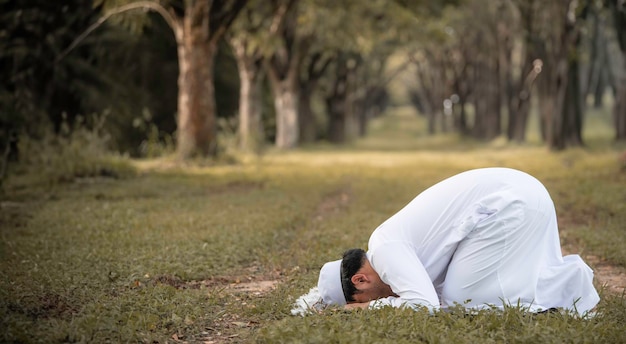 Un jeune homme musulman asiatique priant au coucher du soleil Concept du festival du Ramadan