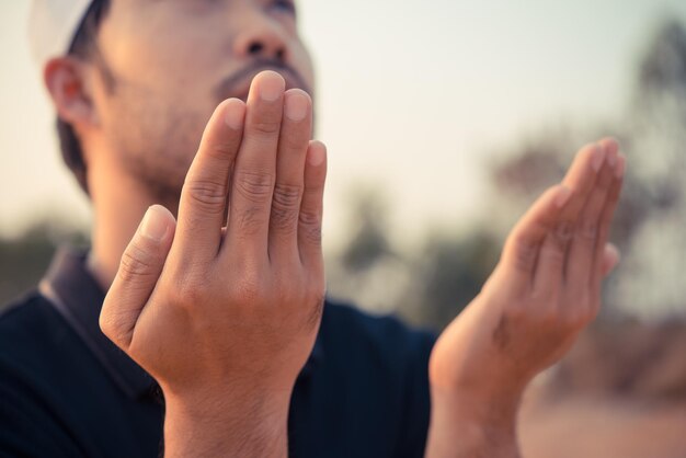 Jeune homme musulman asiatique priant au coucher du soleilConcept du festival du ramadanThaïlandeLes bénédictions d'Allah