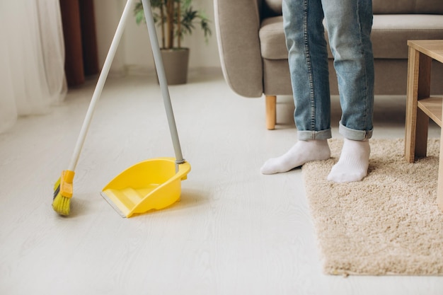 Un jeune homme nettoie la chambre, lave le sol et balaie