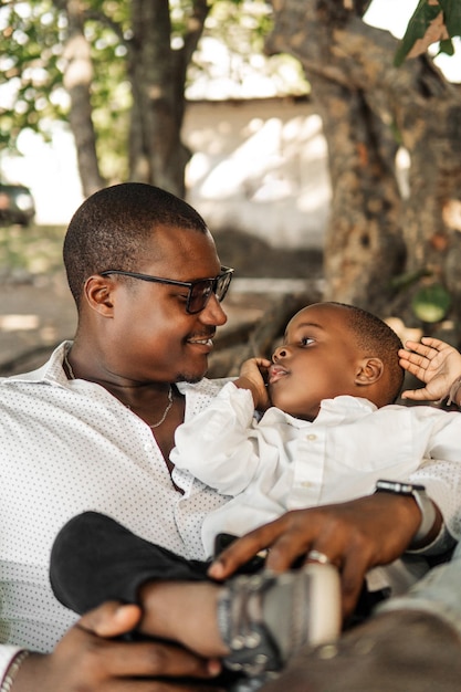 Un jeune homme noir adulte tenant un bébé dans ses bras.