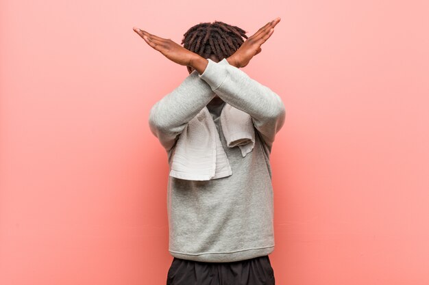 Photo jeune homme noir africain de remise en forme en gardant deux bras croisés, concept de déni.