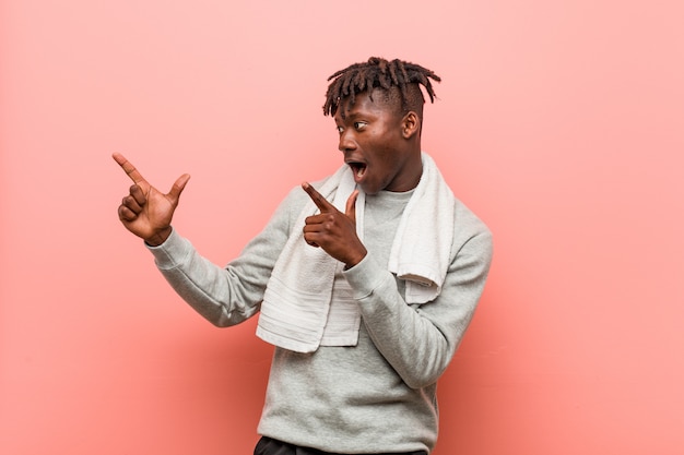 Jeune Homme Noir Africain De Remise En Forme Montrant Quelque Chose Avec Des Index, Exprimant L'excitation Et Le Désir.