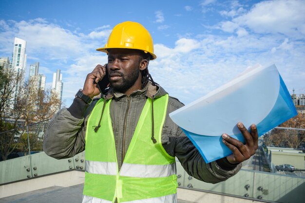 jeune homme noir constructeur parlant au téléphone discutant en colère avec un employé