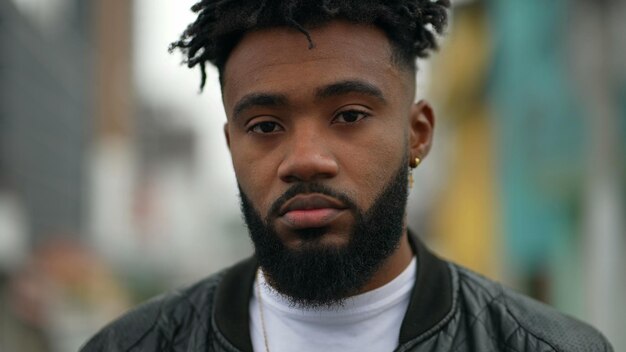 Un jeune homme noir debout à l'extérieur dans la rue regardant la caméra un portrait de personne afro-américaine