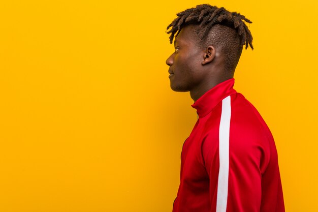 Jeune homme noir fitness regardant à gauche, pose sur le côté.