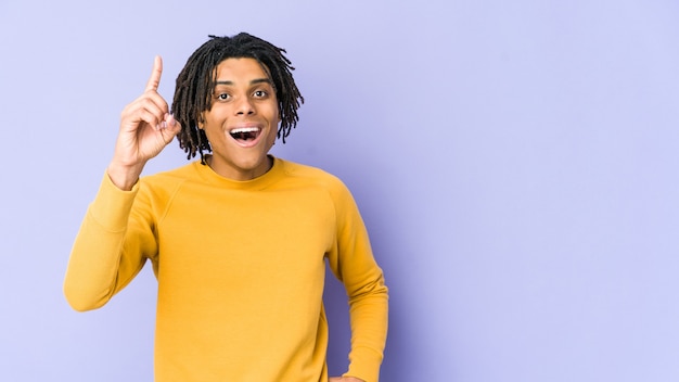 Jeune homme noir portant une coiffure rasta ayant une idée, un concept d'inspiration.