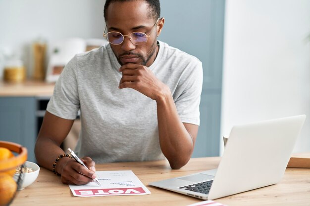 Un jeune homme noir remplissant un document de vote par correspondance