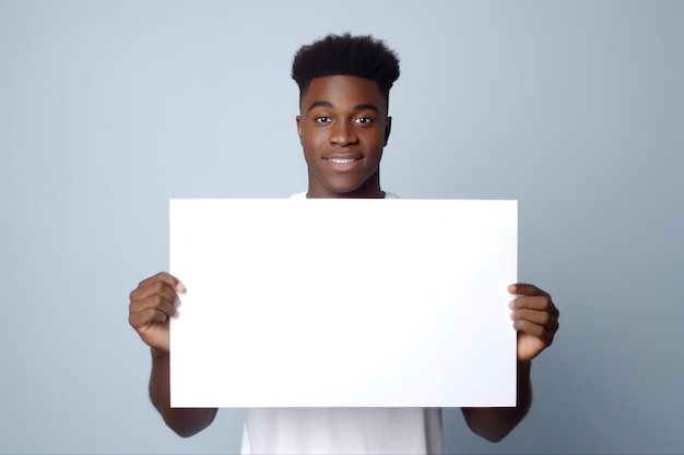 un jeune homme noir tenant une carte de vœux blanche vide