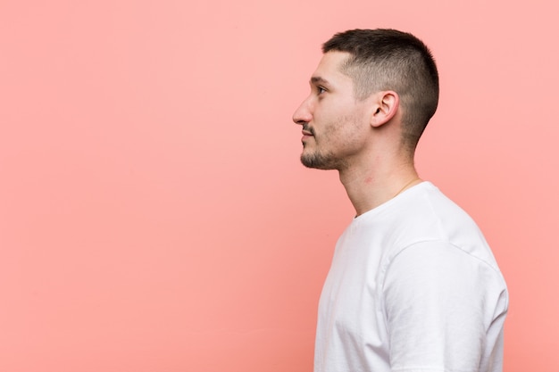 Jeune homme occasionnel regardant à gauche, pose sur le côté.