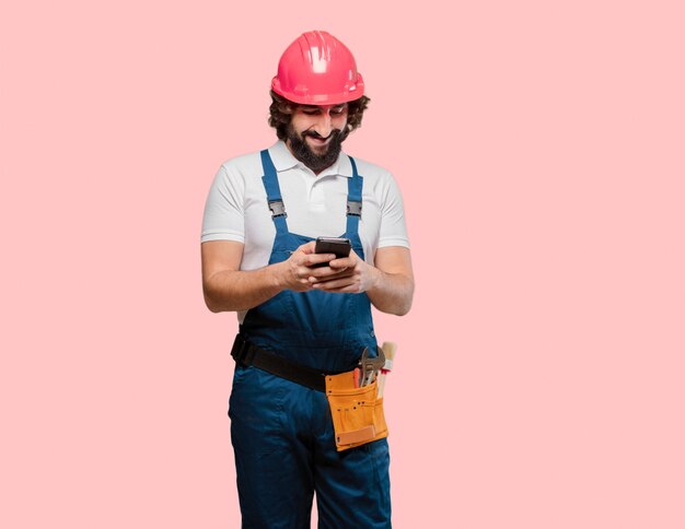 Jeune homme ouvrier avec un téléphone portable