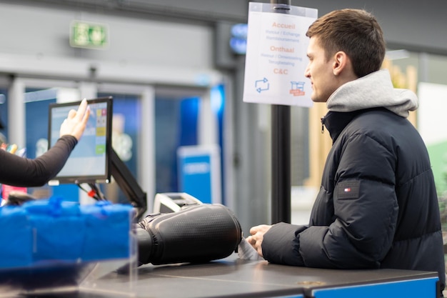 Un jeune homme paie ses achats dans le magasin