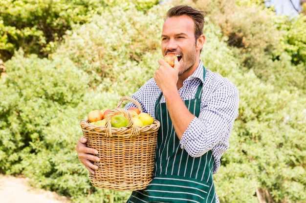 Jeune homme avec panier mange pomme