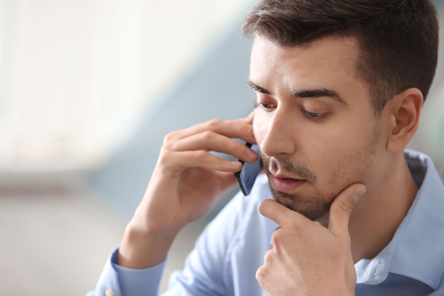 Jeune homme parlant au téléphone au bureau