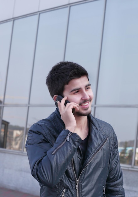 Jeune homme parlant sur un téléphone portable dans la rue