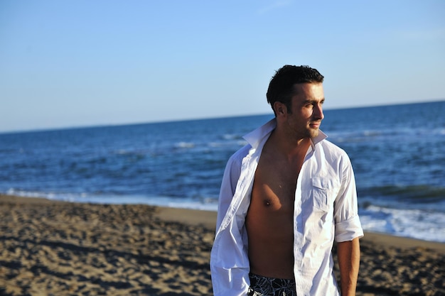 jeune homme passer du bon temps et se détendre sur la belle plage au bord de la mer