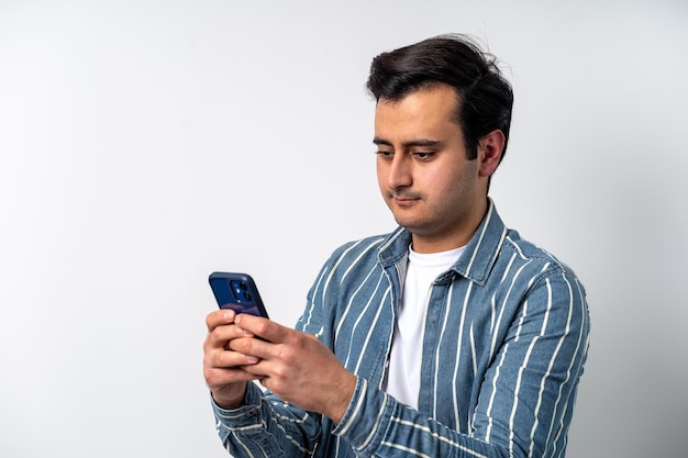 Jeune homme à la peau brune adulte souriant à l'écran tenant un smartphone