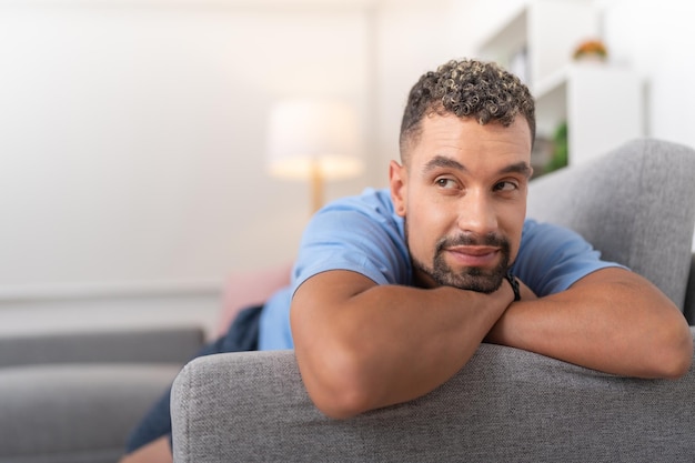 Jeune homme pensant à sa petite amie allongée sur le canapé