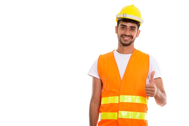 Jeune homme persan heureux travailleur de la construction souriant tout en donnant