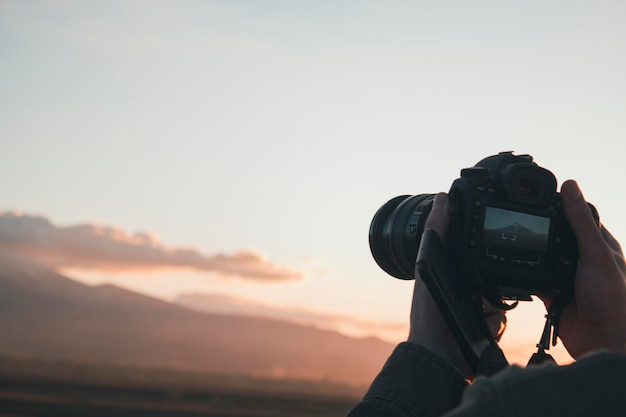 Jeune homme photographiant une montagne