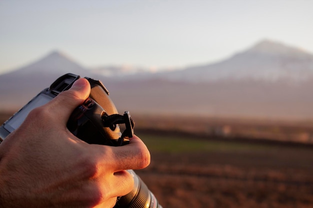 Jeune homme photographiant une montagne