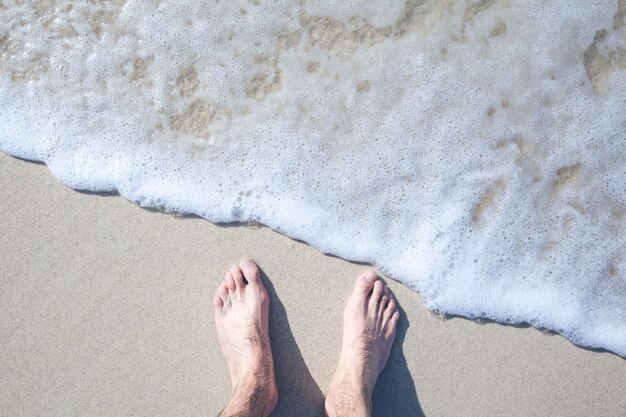 Jeune homme pieds sur la plage