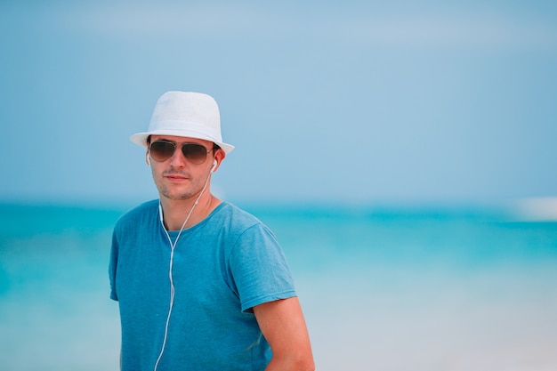 Jeune homme sur la plage tropicale blanche