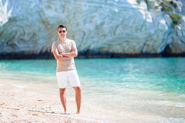 Jeune homme sur la plage tropicale blanche